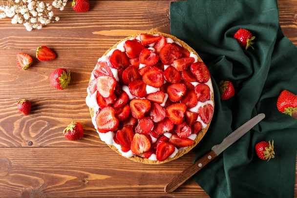 Σύνθεση με νόστιμη πίτα φράουλα σε ξύλινο φόντο - Φωτογραφία, εικόνα