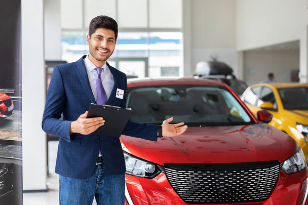 Sales manager toont gloednieuwe auto, holding chart - Foto, afbeelding