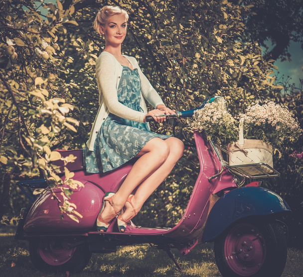 Beautiful blond woman sitting on a retro roller  - Zdjęcie, obraz