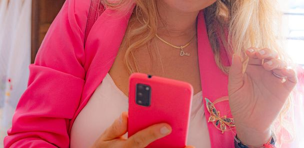 Akıllı telefon ve kelebek şeklinde broşu olan kadın elleri. Alışveriş, online flört, kadınların e-com 'u.. - Fotoğraf, Görsel