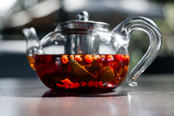 Üvegteáskanna forró vörös bogyós teával, közelkép. - Fotó, kép