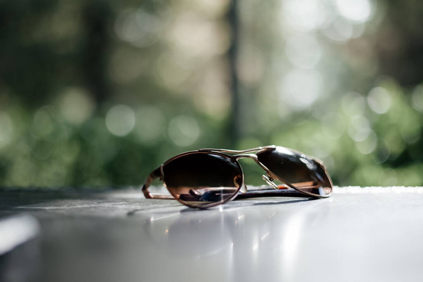 Sunglasses   on a   table.  Selective focus. Bokeh background  - Photo, Image