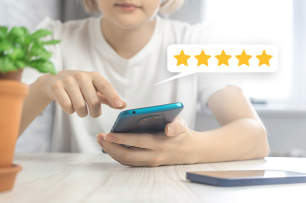 Tevreden klant geeft vijf sterren rating voor de dienst, feedback pictogram met smartphone in handen - Foto, afbeelding