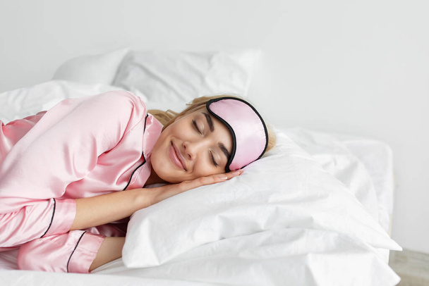 Lady enjoy fresh soft bedding linen pillow in white bedroom - Fotó, kép