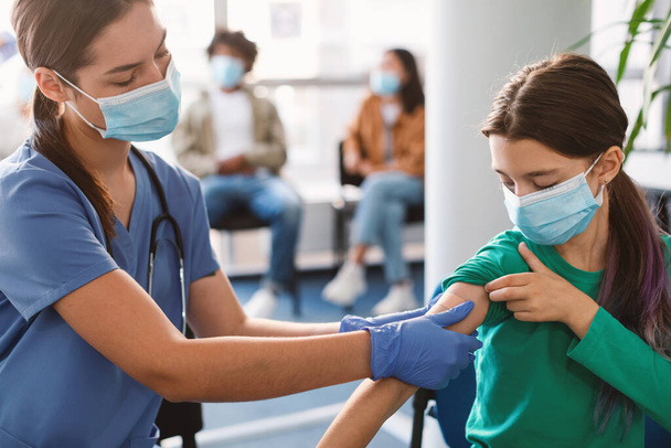 女の子はCovid-19に対してワクチン接種を受けます,医師適用プラスター - 写真・画像