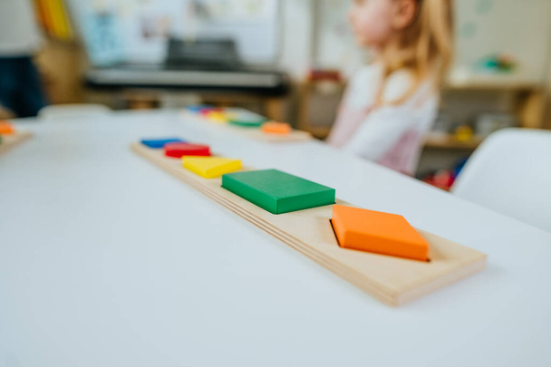 Collection of wooden geometric forms on the table in kindergarten. Educational concept. Selective focus. - Photo, Image