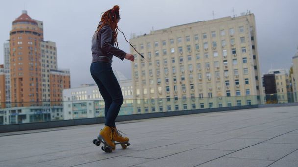 Mujer de jengibre fresco montando en patines. Hipster femenino mostrando patinaje sobre ruedas. - Foto, Imagen
