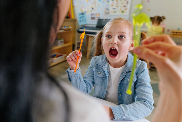 Girl on the session of speech therapist. Lesson on the development of speech in kindergarten. - Fotó, kép