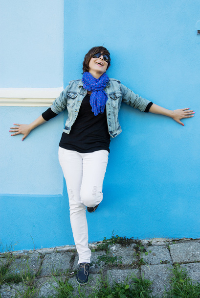piękna kobieta pozytywne pozują przed ścianą niebieski - Zdjęcie, obraz