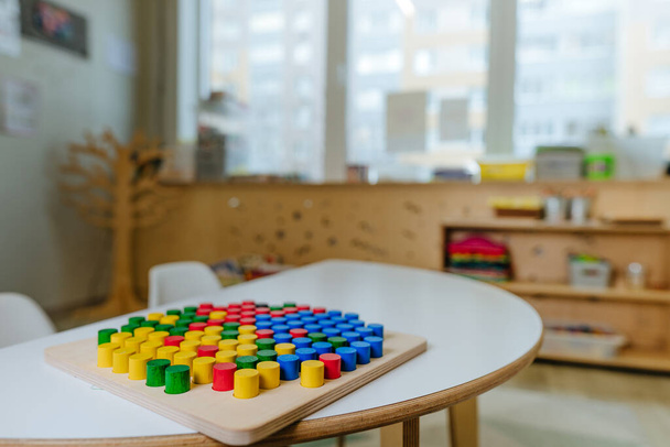 Holzmosaik auf dem Tisch im Kindergarten. Ideal für die Entwicklung von Fantasie und Kreativität. Lernspielzeug aus Naturmaterialien. Selektiver Fokus. - Foto, Bild