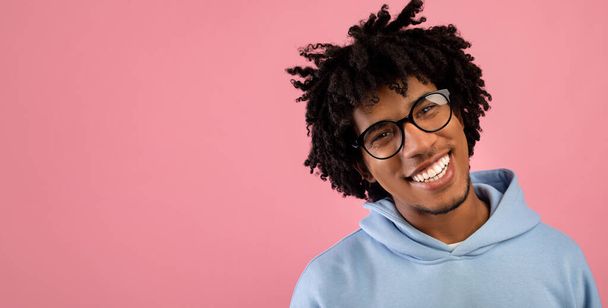 Portrait of handsome black teenager in casual clothes smiling and looking at camera over pink background, free space - Fotografie, Obrázek