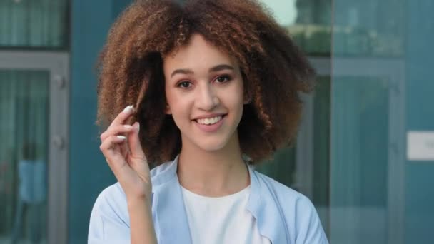 Female portrait outdoors beautiful young seductive sexy ethnic afro american lady girl model african woman standing on street posing looking at camera twist curl of hair on finger flirting seduces - Footage, Video