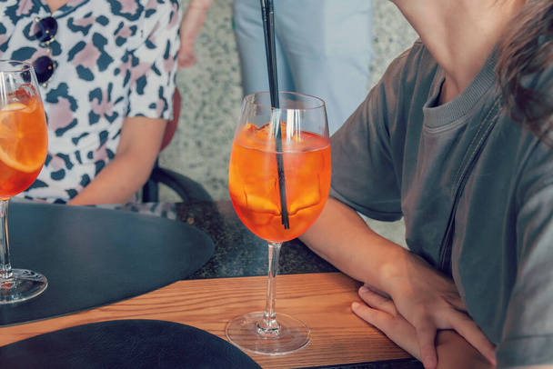 Друзі на літніх канікулах п'ють коктейлі. Дві жінки проводять вільний час у місцевому барі
. - Фото, зображення