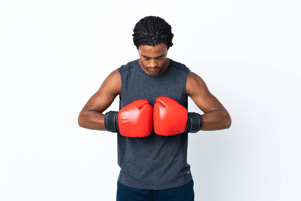 Young African American man with braids isolated on purple background with boxing gloves - Foto, imagen