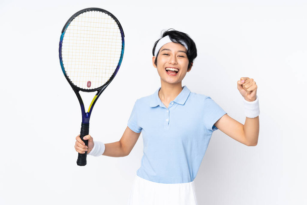 Junge vietnamesische Tennisspielerin über isolierte weiße Wand beim Tennisspielen und stolz auf sich selbst - Foto, Bild