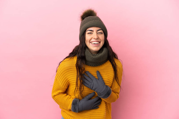 Young caucasian girl with winter hat isolated on purple background smiling a lot - Photo, Image