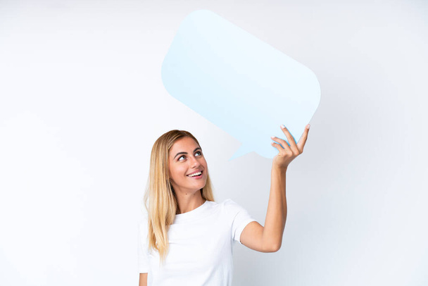 Блондинка уругвайська дівчина ізольована на білому фоні, тримаючи порожню мову бульбашки - Фото, зображення