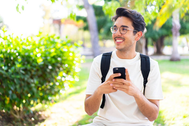 Nuori opiskelija mies ulkona matkapuhelimella - Valokuva, kuva