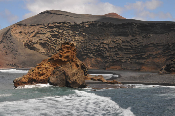 A beautiful view of the wild and rough beach on volcanic island Lanzarote, Spain - Фото, изображение