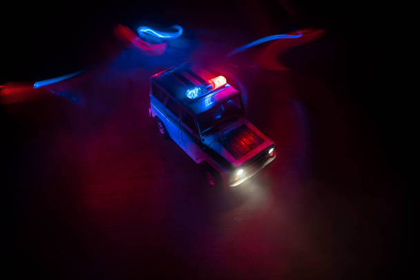 Поліцейський автомобіль переслідує машину вночі з тлом туману. 911 Аварійне реагування поліцейський автомобіль прискорюється до місця злочину. Творче оздоблення. Вибірковий фокус
 - Фото, зображення