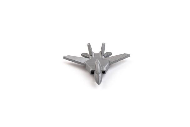 Modell eines grauen Miniatur-Kampfjets auf einem 3D-Drucker, auf weißem Hintergrund. Verkehrskonzept - Foto, Bild