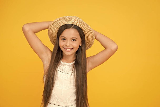 Enjoying hot day. little child ready for beach activity. happy childhood. joyful summer holiday and vacation. kid seasonal fashion. carefree beauty on yellow background. smiling kid in straw hat - Foto, Imagen