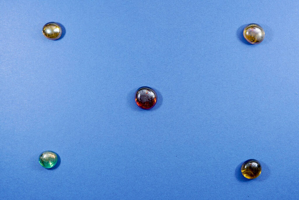 Плоская композиция из цветного драгоценного камня, выделенного на синем фоне с свободным местом для текста - Фото, изображение