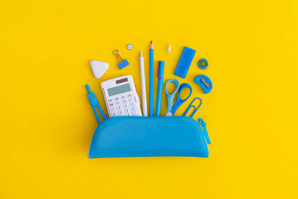 Pencil case with school stationery on a yellow background. Top view. Flat lay. Back to school concept. - Fotó, kép