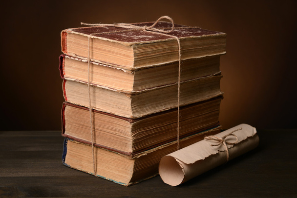 Stare książki na stole na brązowym tle  - Zdjęcie, obraz