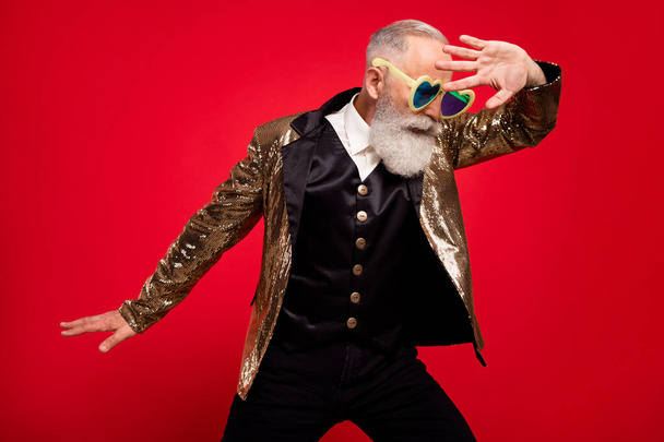 Photo of aged handsome man performance wear eyeglasses circus comic performance isolated over red color background - Φωτογραφία, εικόνα