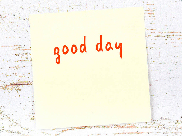 Κίτρινη αυτοκόλλητη σημείωση στον ξύλινο τοίχο με χειρόγραφη επιγραφή καλή μέρα - Φωτογραφία, εικόνα