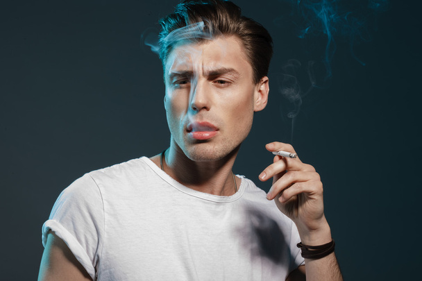Handsome young man smoking cigarette - Fotoğraf, Görsel