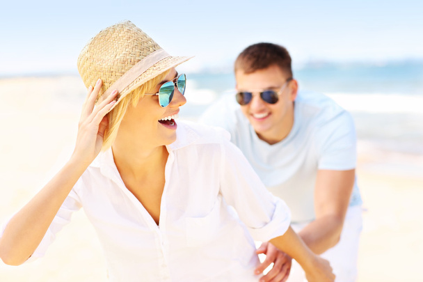 Homme heureux pourchassant une femme à la plage
 - Photo, image