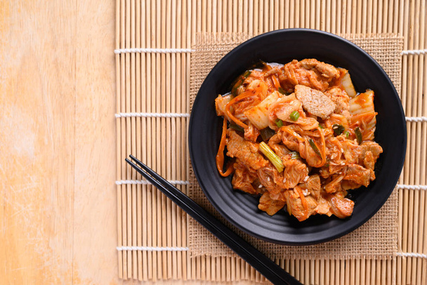 Comida coreana, Repolho de kimchi frito com porco e pauzinhos no fundo de madeira, Vista superior da mesa - Foto, Imagem