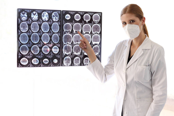 Γυναίκα νευρολόγος ειδικός επαγγελματίας γιατρός με μάσκα αναθεώρηση τομογραφίες του εγκεφάλου - Φωτογραφία, εικόνα
