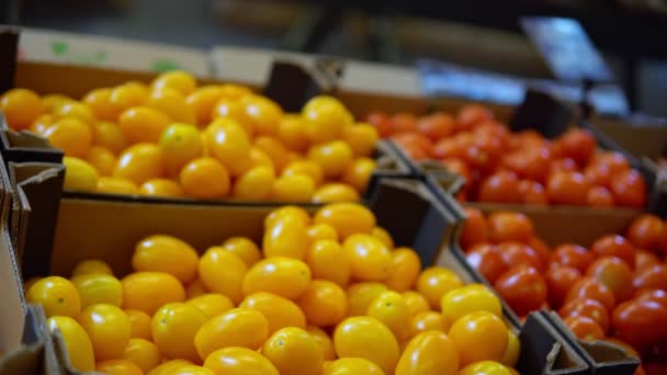 Mujer eligiendo tomates amarillos de la caja en el supermercado. Hortalizas frescas - Metraje, vídeo