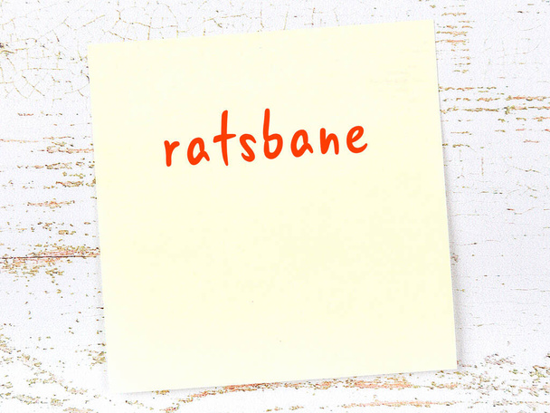 Concepto de recordatorio sobre ratsbane. Hoja adhesiva amarilla de papel sobre pared de madera con inscripción - Foto, imagen