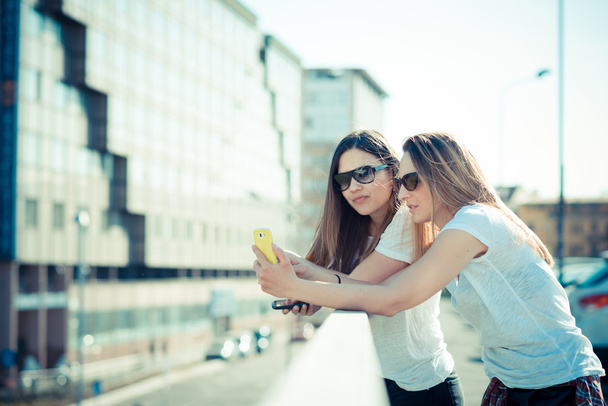 due belle giovani donne che utilizzano lo smartphone
 - Foto, immagini