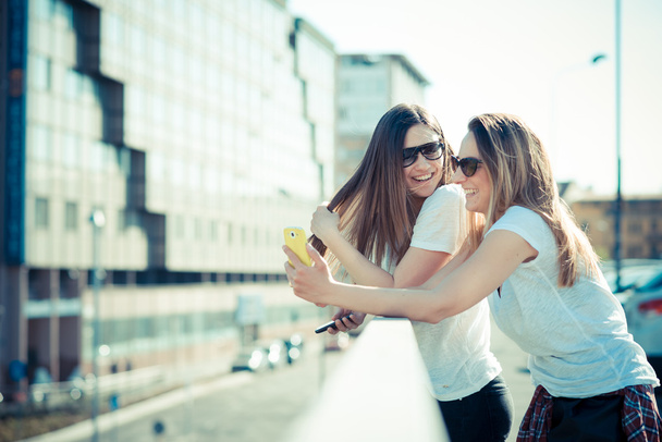 zwei schöne junge Frauen mit Smartphone - Foto, Bild