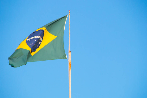 Flaga Brazylii na zewnątrz z pięknym błękitnym niebem w tle w Rio de Janeiro Brazylia. - Zdjęcie, obraz