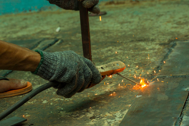 A mechanic is welding steel with sparks. - Valokuva, kuva