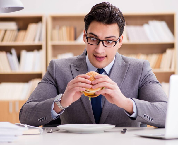 Hambriento empresario divertido comer sándwich de comida chatarra - Foto, imagen