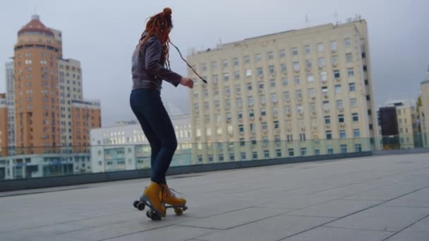 Mujer de jengibre fresco montando en patines. Hipster femenino mostrando patinaje sobre ruedas. - Metraje, vídeo