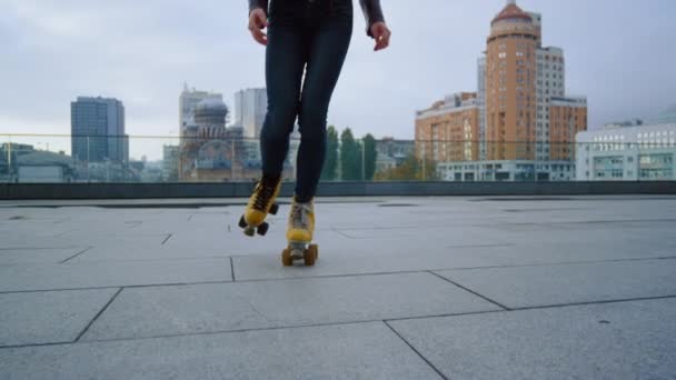 Mujer irreconocible que tiene entrenamiento de patinaje en la azotea de la ciudad. - Metraje, vídeo
