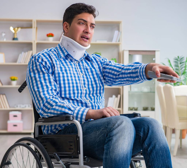 Joven que sufre de lesiones en silla de ruedas en casa - Foto, imagen