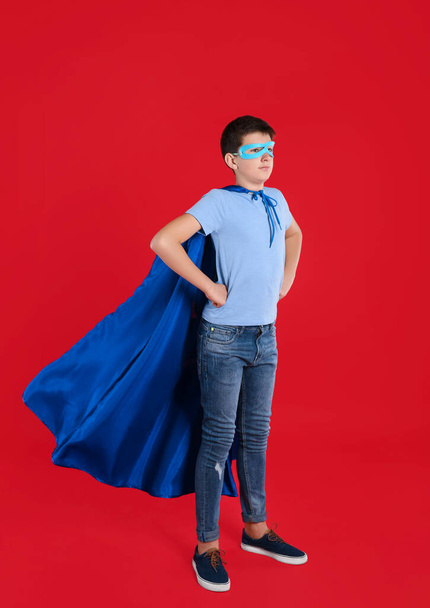 Teenage boy in superhero costume on red background - Φωτογραφία, εικόνα