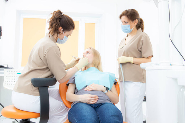 mujer embarazada en el consultorio de dentistas, chequeo y tratamiento dental para mujeres embarazadas. - Foto, Imagen