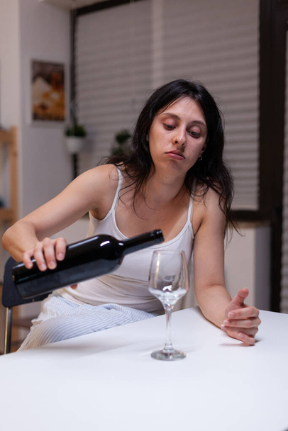 Алкоголичка выпивает бутылку вина и бокал грустит - Фото, изображение