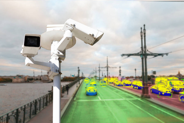 The concept of video surveillance and security technology. A surveillance camera monitors the violators of traffic rules. In the background, the road of different congestion. - Photo, Image