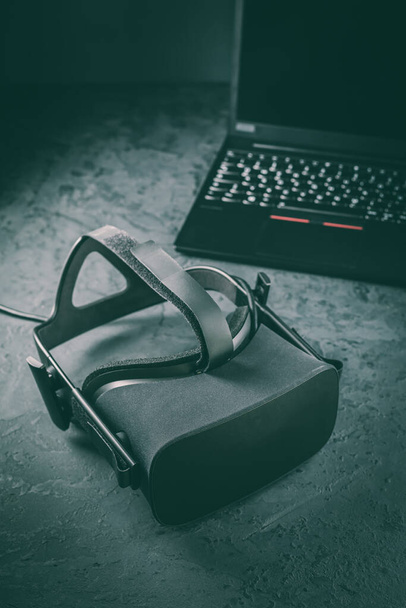 VR kulaklık - gerçekliğin simülasyonu için sanal gerçeklik gözlükleri farklı multimedya ve arka planda dizüstü bilgisayar  - Fotoğraf, Görsel